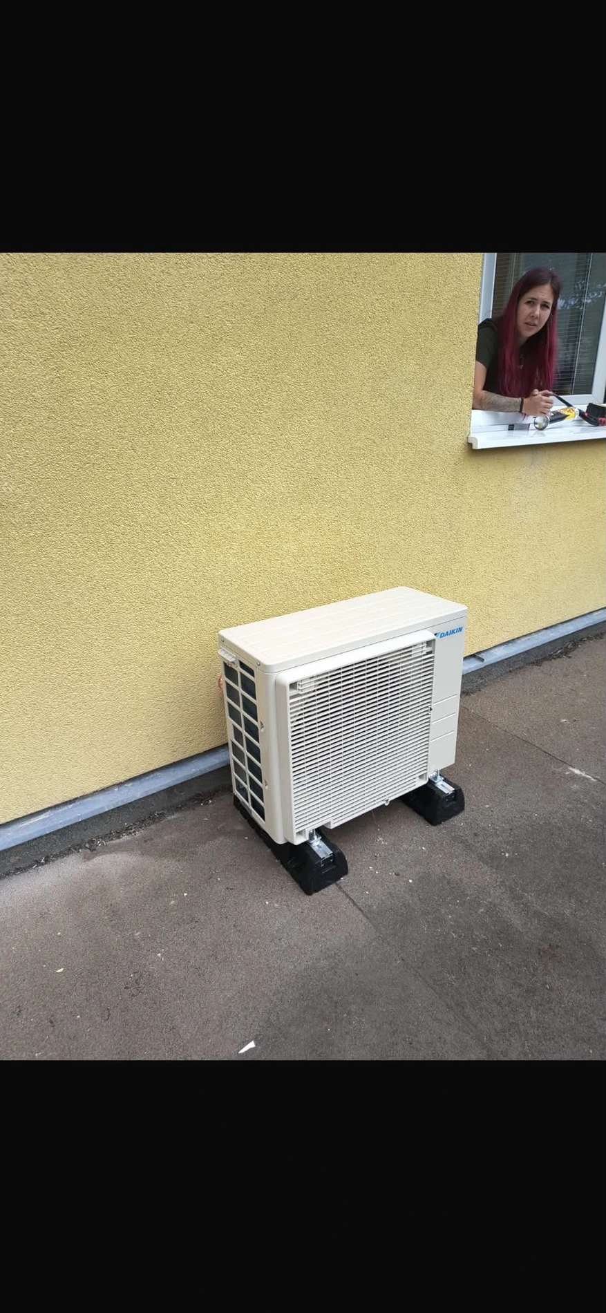 Venkovní jednotka u žluté fasády