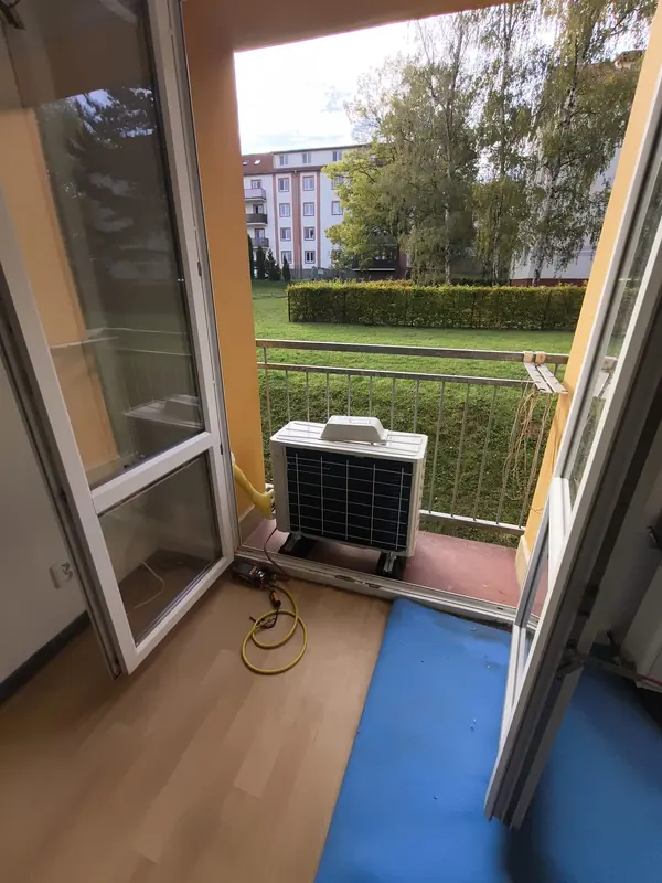 Venkovní jednotka na balkonu a měřicí souprava na podlaze