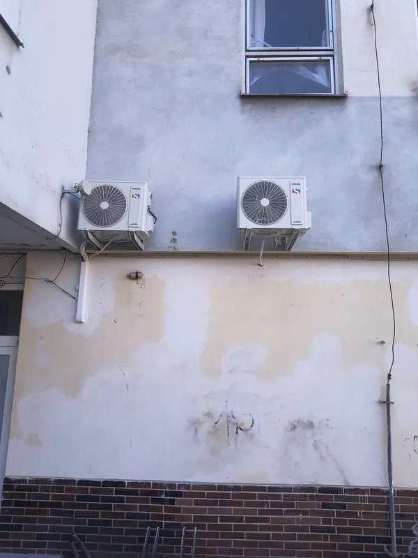 Dvě venkovní jednotky Sinclair na konzolách na fasádě domu